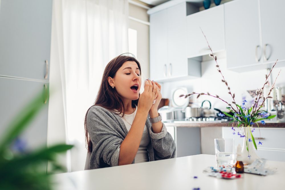 Žena si ide kýchnuť, čo môže spôsobiť prasknutie nosných cievok, čo spôsobí krvácanie z nosa.