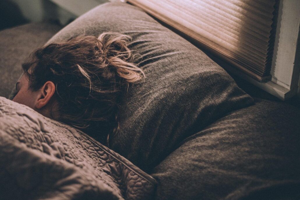 Hypersomnia (spavosť) - žena spiaca na vankúši s hlavou otočenou na bok
