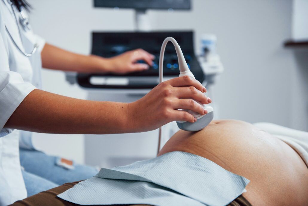 Doktorka robí ultrazvuk tehotnej žene a zisťuje, či je všetko v poriadku, či sa dieťa hýbe, zároveň jej odporučí prenatálny test ako je napríklad test na downov syndróm