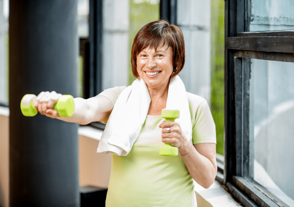 Žena v strednom veku cvičí s činkami, čím dokáže zmierniť príznaky klimaktéria.