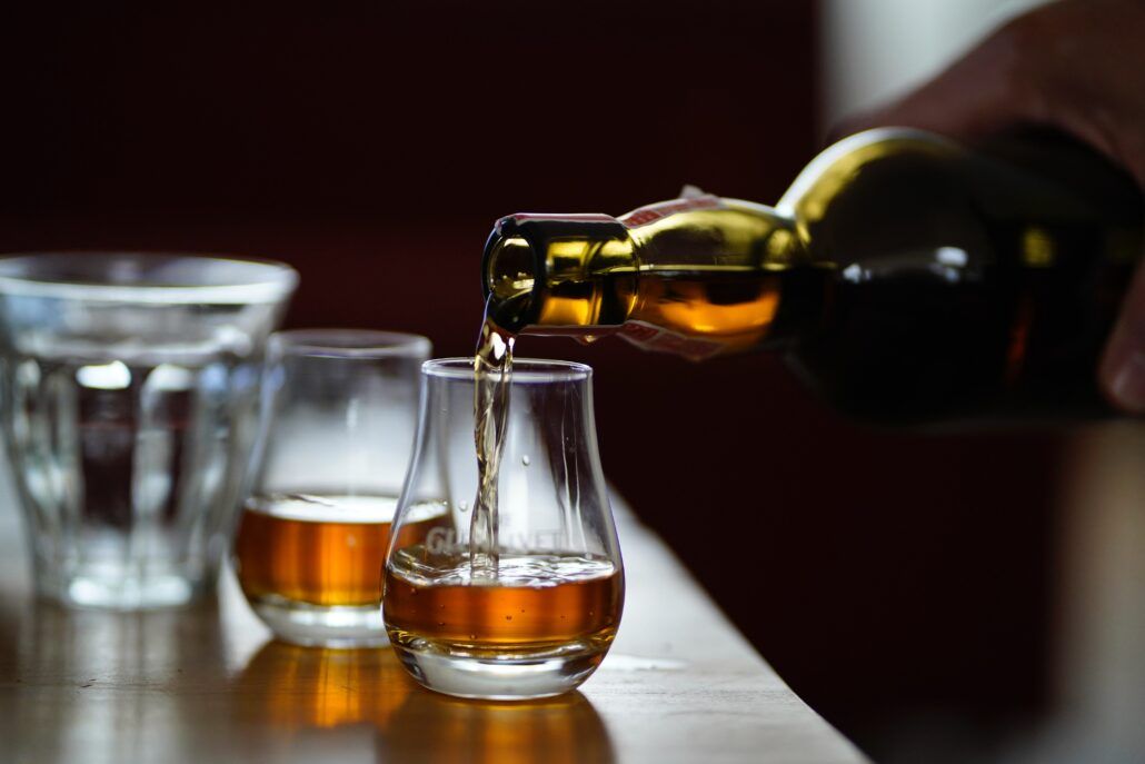 Nezaťažujte imunitu - užívanie alkohol. Nalievanie whisky do pohárikov.