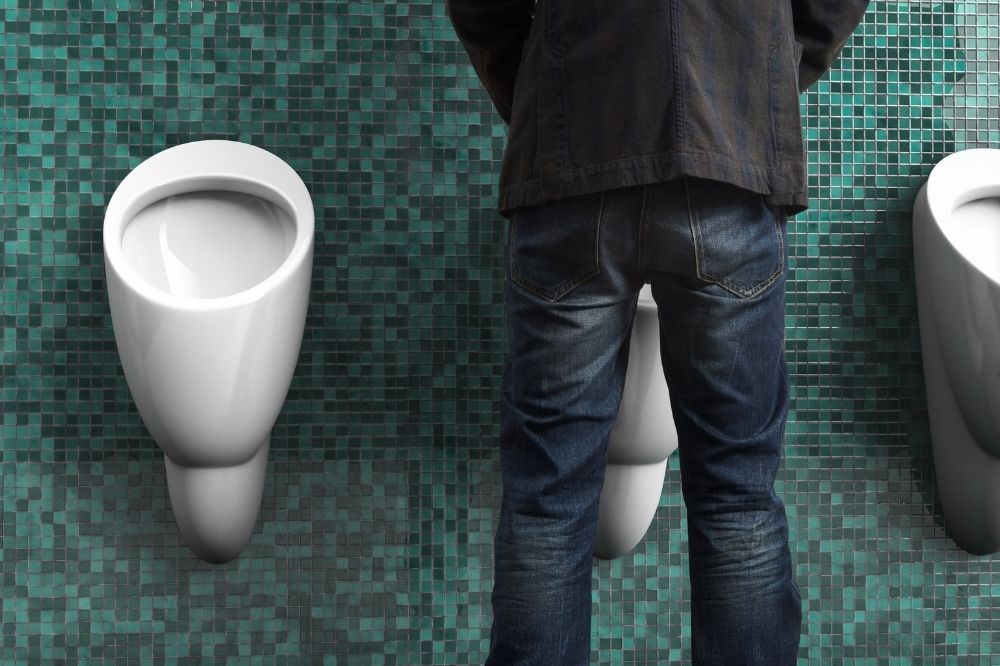Zväčšená prostata - problémy s močením. Muž stojí pred wc misou.