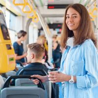 Žena stojí v MHD a usmieva sa pretože je chránená v uzavretých priestoroch, kde potrebuje silnejšiu imunitu.