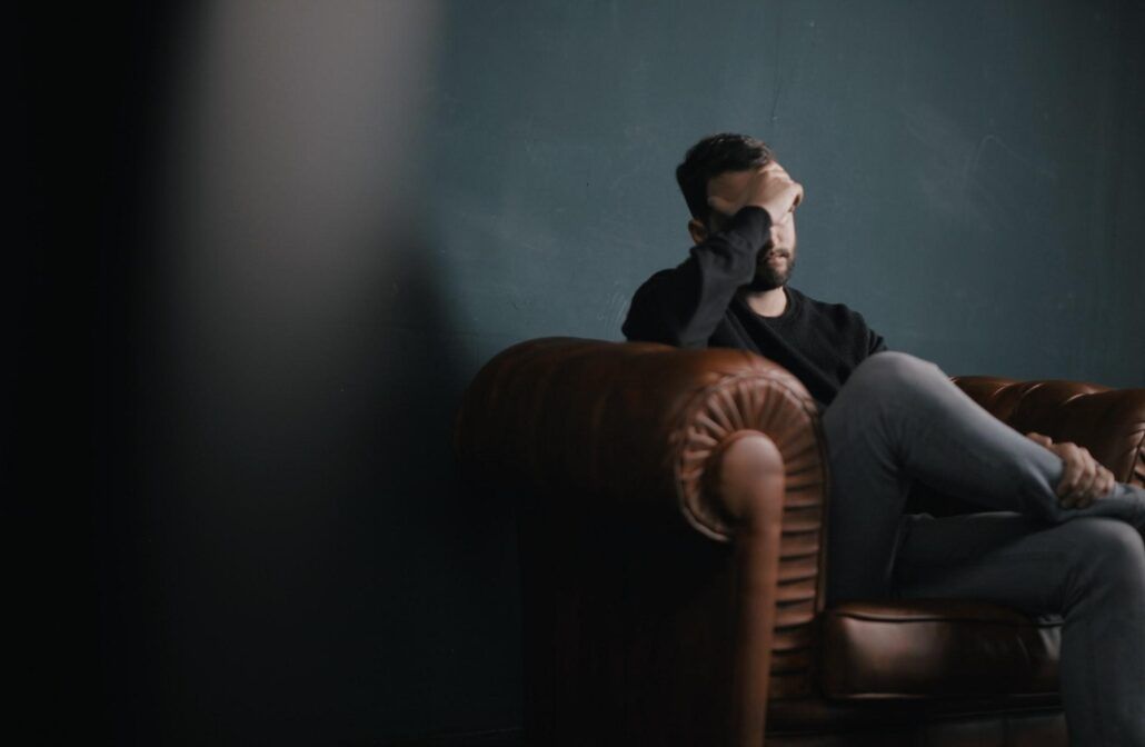 Migréna - muž sediaci na gauči